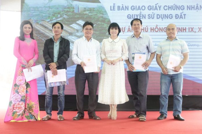 Bà Phạm Thị Hường trao sổ hồng cho khách hàng mua nhà đất tại dự án của công ty
